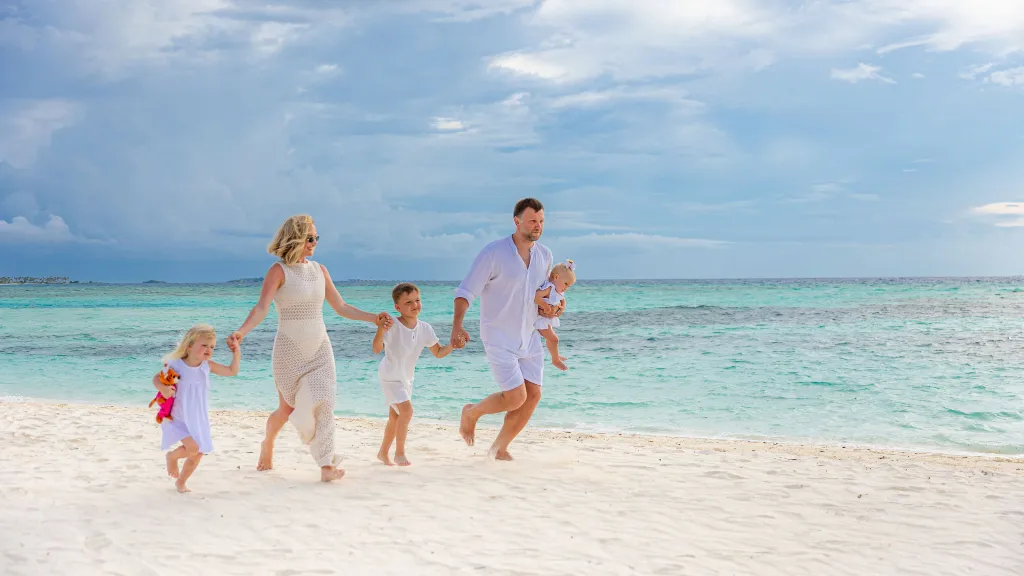 Family strolling along a tropical beach on a luxury vacation