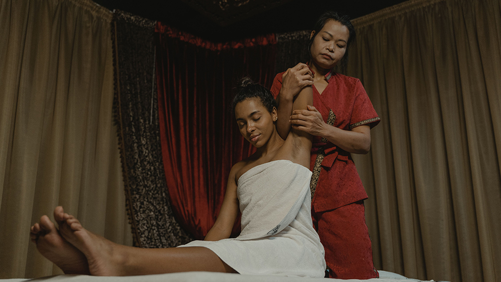 Guest enjoying a relaxing spa massage with a professional therapist in a tranquil wellness treatment room.