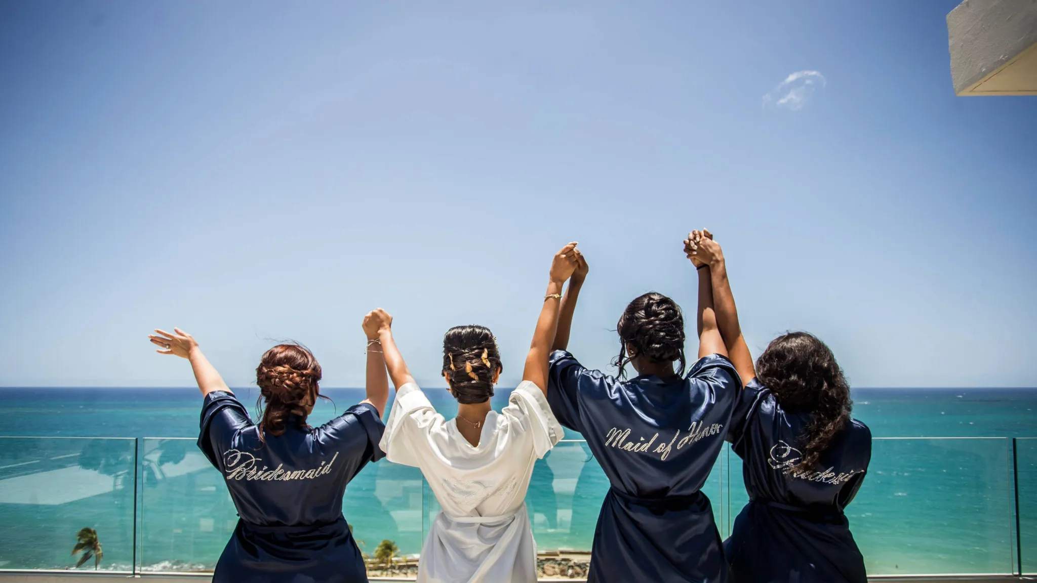 Bachelorette party with friends wearing robes in beachfront setting